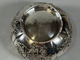 an antique silver plate with a floral design on the rim