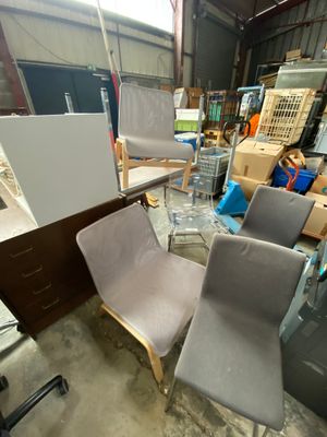 a lot of chairs and a table in a warehouse