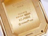 an image of a gold watch with a black strap on a white surface