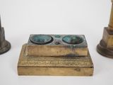 two antique brass candlesticks and a brass candle holder on a white background