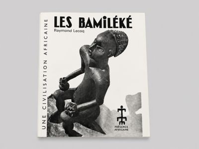 une photo en noir et blanc d'un livre sur lequel se trouve une statue