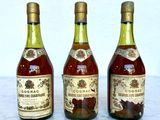 three bottles of wine sitting on a marble table