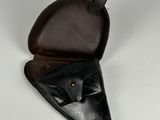a close up of a pair of black leather holsters on a white surface