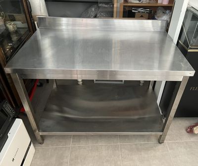 une table en acier inoxydable surmontée d'une vitrine en verre