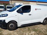 une camionnette blanche garée devant un bâtiment