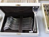 many forks and spoons in a box on a table