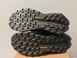 a pair of black hiking shoes sitting on top of a cardboard box