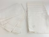 plusieurs serviettes blanches pliées posées sur une table blanche