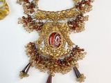un collier en or orné d'un motif rouge et blanc