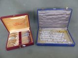two boxes with silverware in them on a table