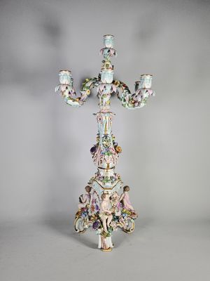 un candélabre richement décoré, muni de trois bougies et posé sur un socle