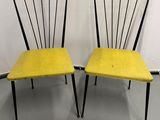 une paire de chaises jaunes aux pieds noirs et à l'assise jaune