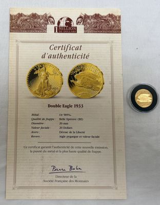 une pièce d'or accompagnée d'un certificat, à côté d'une autre pièce d'or
