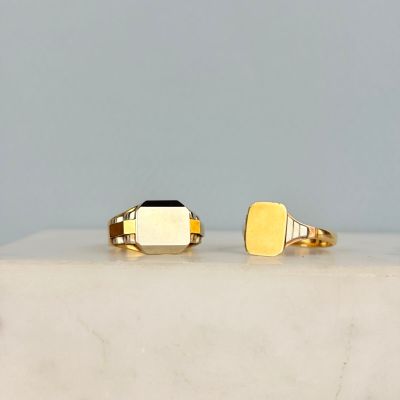 deux bagues en or ornées d'un sceau rectangulaire posé sur une dalle de marbre