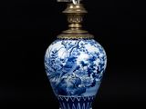 vase bleu et blanc surmonté d'un oiseau, posé sur un socle