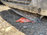 a piece of plastic on the ground next to a car