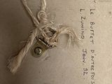 a string tied to a piece of paper with a lock on it