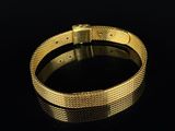 a close up of a gold bracelet on a black surface