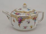 a white tea pot with a gold rim and flowers on it