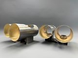 two silver and gold vases sitting on top of each other