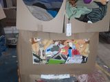 une boîte en carton posée par terre, contenant des peluches