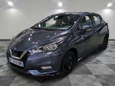 a grey nissan versa parked in a room with a checkered floor