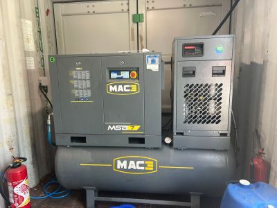 two air compressors in a storage room next to a fire hydrant