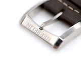 a brown leather strap with a silver buckle on it