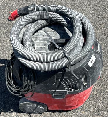 a red and black blow dryer sitting on the ground