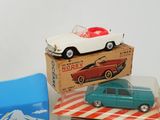 three toy cars sitting on top of boxes on a table