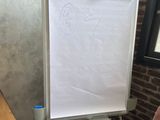 a white board with a drawing on it in front of a window