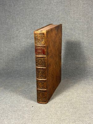 an old book sitting on top of a table next to a gray background