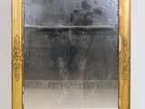 a gold framed mirror sitting on a white surface