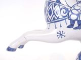 a blue and white horse figurine on a white surface