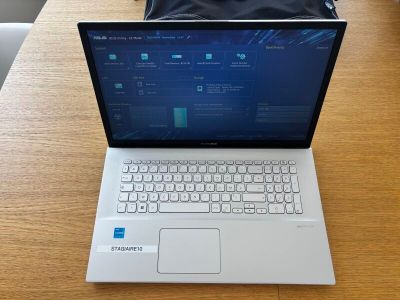 un ordinateur portable posé sur une table, avec un sac dessus