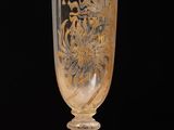 un verre orné d'un motif doré, posé sur une table