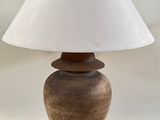 a lamp that is sitting on a table with a white shade on it