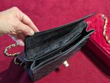 a person holding a red purse with a chain around it