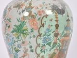 a vase with a lid that is decorated with flowers and birds
