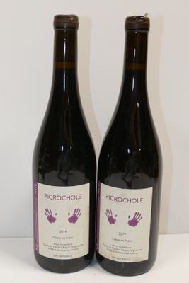 deux bouteilles de vin posées sur une table l'une à côté de l'autre