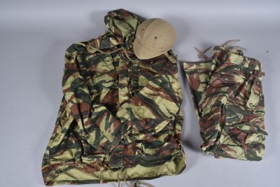 une veste de camouflage et un chapeau posés sur une surface blanche