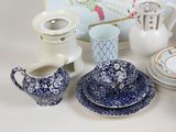 a lot of blue and white dishes and cups on the table