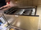 a stainless steel sink with two kegs inside of it