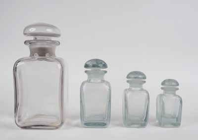 HERMES Garniture en verre comprenant quatre flacons et leur …