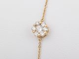 a yellow gold chain with a flower pendant on it