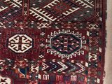 un vieux tapis rouge et bleu orné de nombreux motifs différents