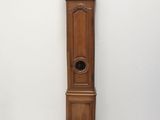 une grande horloge de parquet en bois posée à côté d'une bobine de fil posée par terre