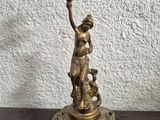 brass candle holder with a statue of a woman holding a candle