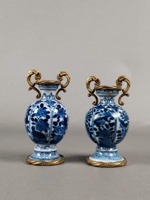 pair of blue and white vases sitting on top of a table