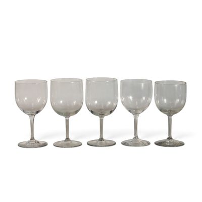 quatre verres à vin sont alignés sur une surface blanche